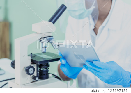 Indian Scientist man look into Microscope research in science laboratory. Asian biochemistry scientist using microscope in laboratory chemistry labs. Covid-19 medical research scientific experiment Indian Scientist man look into Microscope research in science laboratory. Asian biochemistry scientist using microscope in laboratory chemistry labs. Covid-19 medical research scientific experiment 127697121