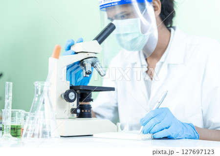 Scientist man look into Microscope research in science laboratory. Asian scientist looking equipment laboratory chemistry labs. Covid-19 coronavirus biochemistry research experiment vaccine concept Scientist man look into Microscope research in science laboratory. Asian scientist looking equipment laboratory chemistry labs. Covid-19 coronavirus biochemistry research experiment vaccine concept 127697123