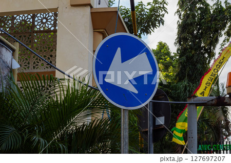 Blue Left Turn Traffic Sign in Urban Setting 127697207