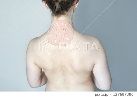 Female with shoulder pain relief patch on back for therapeutic treatment Female with shoulder pain relief patch on back for therapeutic treatment 127697396