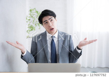 パソコンを前に信じられないとお手上げ状態なスーツを着たビジネスマン男性 仕事辞めよう パソコンを前に信じられないとお手上げ状態なスーツを着たビジネスマン男性 仕事辞めよう 127697782