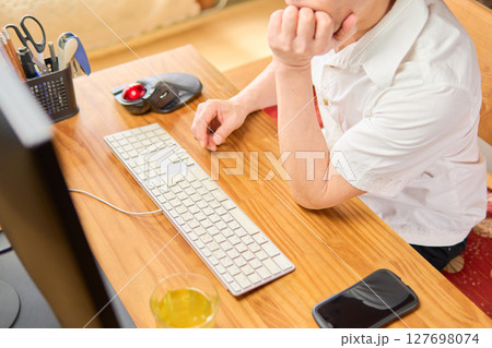 パソコンの画面を見つめて考えごとをする50代男性 パソコンの画面を見つめて考えごとをする50代男性 127698074
