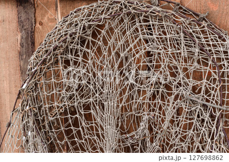 Old fishing nets hanging on wooden wall Old fishing nets hanging on wooden wall 127698862