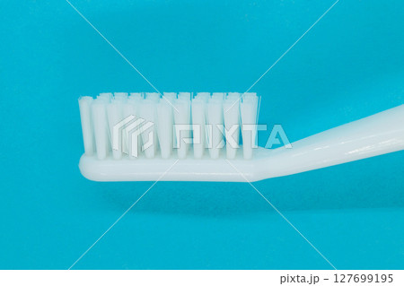 White toothbrush on blue background White toothbrush on blue background 127699195