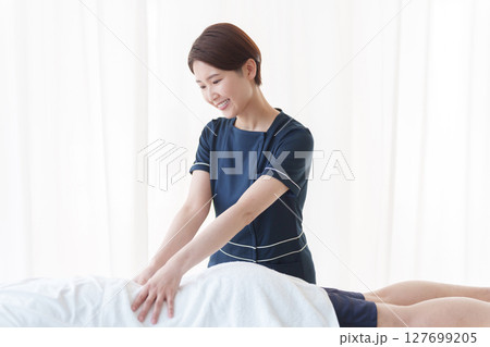 客に施術するエステティシャン 客に施術するエステティシャン 127699205