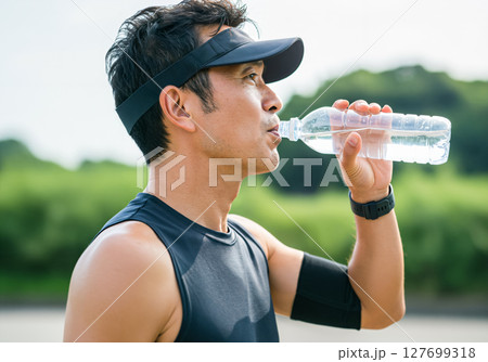 ランニング後に水分補給をするミドル世代の男性 127699318