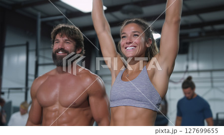 Celebrating fitness success with arms raised in victory at gym workout 127699655