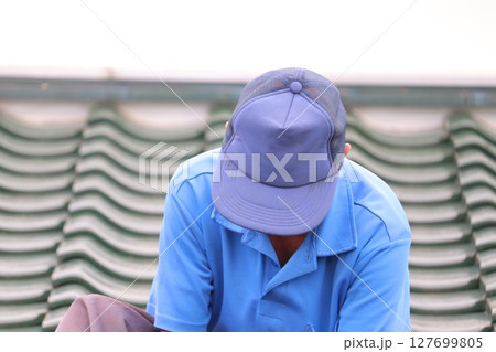 屋根の雨漏りを治すシニアおじさん 屋根の雨漏りを治すシニアおじさん 127699805