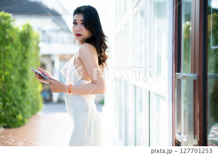 beautiful asian freelance Success people business woman fashion model in summer white sleeveless dress using casual working with tablet for browsing internet, chatting and blogging in coffee shop. beautiful asian freelance Success people business woman fashion model in summer white sleeveless dress using casual working with tablet for browsing internet, chatting and blogging in coffee shop. 127701253