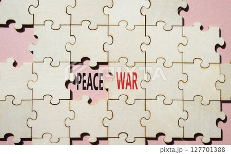 War or Peace symbol. Concept word War or Peace on wooden puzzle. Beautiful pink background. Business and War or Peace concept. Copy space War or Peace symbol. Concept word War or Peace on wooden puzzle. Beautiful pink background. Business and War or Peace concept. Copy space 127701388