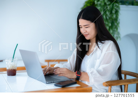 asian freelance people business female wearing smartwatch talking making using casual working with laptop computer for browsing internet, chatting and blogging and smartphone,notebook in coffee shop. asian freelance people business female wearing smartwatch talking making using casual working with laptop computer for browsing internet, chatting and blogging and smartphone,notebook in coffee shop. 127701555