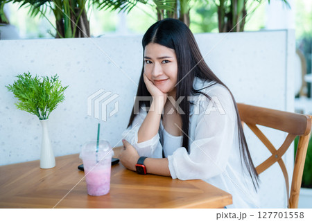 modern portrait of beautiful happy asian woman traveler wearing smartwatch wearing beautiful white dress and wear jeans lifestyle enjoying in sitting coffee shop restaurant background 127701558