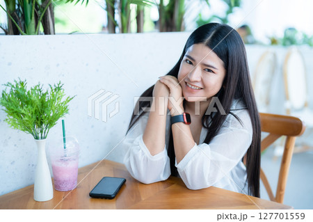 modern portrait of beautiful happy asian woman traveler wearing smartwatch wearing beautiful white dress and wear jeans lifestyle enjoying in sitting coffee shop restaurant background modern portrait of beautiful happy asian woman traveler wearing smartwatch wearing beautiful white dress and wear jeans lifestyle enjoying in sitting coffee shop restaurant background 127701559