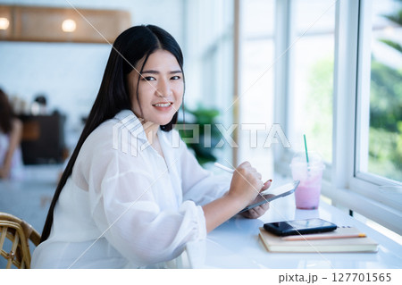 asian freelance people business female wearing smartwatch talking making using casual working with tablet for browsing internet, chatting and blogging and smartphone,notebook in coffee shop. asian freelance people business female wearing smartwatch talking making using casual working with tablet for browsing internet, chatting and blogging and smartphone,notebook in coffee shop. 127701565
