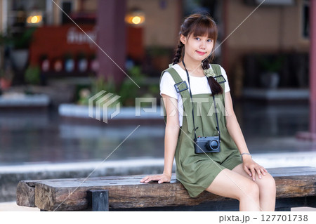Portrait Young asian woman smiling tourist Traveler girl walking and with a holding the camera waits train travel journey is taken in railway platform Thailand, summer relax vacation Concept. Portrait Young asian woman smiling tourist Traveler girl walking and with a holding the camera waits train travel journey is taken in railway platform Thailand, summer relax vacation Concept. 127701738