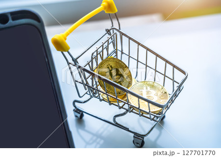 Close-up of Golden bitcoins or cryptocurrency coin or symbols in shopping cart and tablet in white table. Future currency concept. Close-up of Golden bitcoins or cryptocurrency coin or symbols in shopping cart and tablet in white table. Future currency concept. 127701770