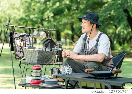 キャンプ場の芝生のサイトでソロキャンプする中年男性キャンパー キャンプ場の芝生のサイトでソロキャンプする中年男性キャンパー 127701794