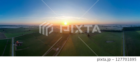 Mesmerizing Aerial View of a Beautiful Sunrise Over Expansive Fields and Farmland Landscape 127701895