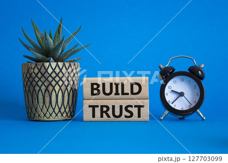 Build trust symbol. Wooden blocks with words Build trust. Beautiful blue background with alarm clock and succulent plant. Business and Build trust concept. Copy space. Build trust symbol. Wooden blocks with words Build trust. Beautiful blue background with alarm clock and succulent plant. Business and Build trust concept. Copy space. 127703099