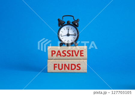 Passive Funds symbol. Concept words Passive Funds on wooden blocks. Beautiful blue background with alarm clock. Business and Passive Funds concept. Copy space. Passive Funds symbol. Concept words Passive Funds on wooden blocks. Beautiful blue background with alarm clock. Business and Passive Funds concept. Copy space. 127703105