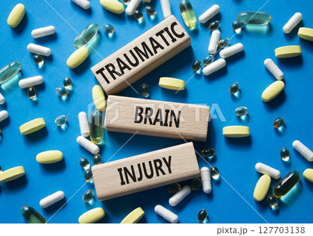 Traumatic Brain Injury symbol. Concept words Traumatic Brain Injury on wooden blocks. Beautiful blue background with pills. Healthcare and Traumatic Brain Injury concept. Copy space. Traumatic Brain Injury symbol. Concept words Traumatic Brain Injury on wooden blocks. Beautiful blue background with pills. Healthcare and Traumatic Brain Injury concept. Copy space. 127703138