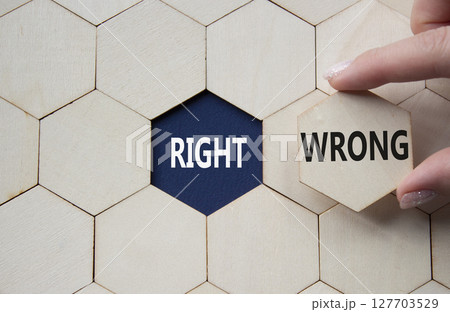 Right or Wrong symbol. Concept word Right or Wrong on wooden comb puzzle. Businessman hand. Beautiful deep blue background. Business and Right or Wrong concept. Copy space Right or Wrong symbol. Concept word Right or Wrong on wooden comb puzzle. Businessman hand. Beautiful deep blue background. Business and Right or Wrong concept. Copy space 127703529