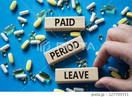 Paid Period Leave symbol. Concept words Paid Period Leave on wooden blocks. Beautiful blue background with pills. Doctor hand. Healthcare and Paid Period Leave concept. Copy space. 127703551
