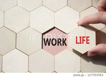 Life or Work symbol. Concept word Life or Work on wooden comb puzzle. Businessman hand. Beautiful pink background. Business and Life or Work concept. Copy space 127703563