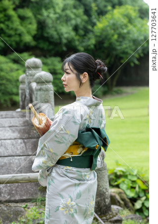 和傘と浴衣姿の若い女性の後ろ姿　日本人 127703641