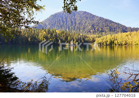 A beautiful autumn landscape.Reflection of the mountain and trees in the lake. A beautiful autumn landscape.Reflection of the mountain and trees in the lake. 127704018
