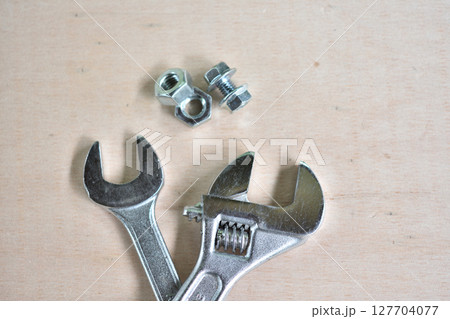 木の板の上に置かれたレンチとネジ 127704077