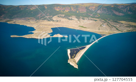 Lake Baikal from the air. View of the bay near the village of Kurma, Cape Uyuga. Lake Baikal from the air. View of the bay near the village of Kurma, Cape Uyuga. 127704555