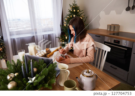 A young girl cooks Christmas gingerbread at home in the kitchen. 127704753