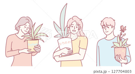 Three individuals are holding various indoor plants that exhibit soft and calming colors 127704803