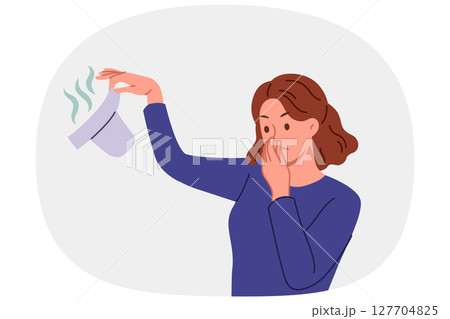 Woman with smelly baby diaper in hand covers nose, feeling disgusting smell caring for child 127704825