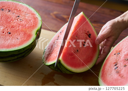 スイカを切り分ける男性 127705225