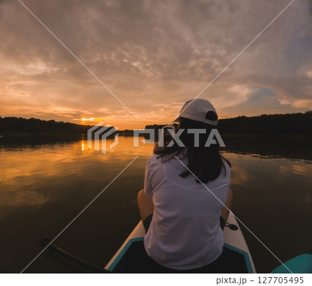 Paddleboarding at Sunset on a Calm Lake 127705495