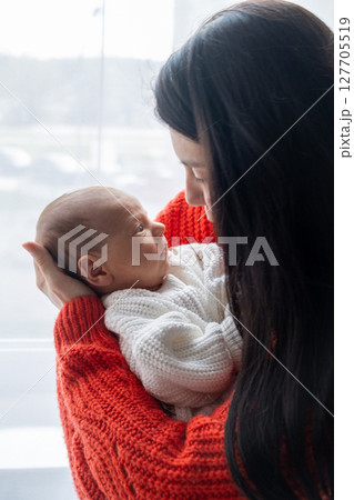 Tender Moment Between Mother and Baby by the Window 127705519