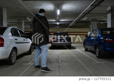 Person in Underground Parking Garage Figure Out of Stolen Car 127705521