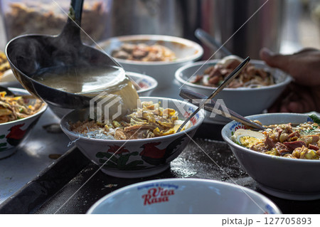 Pouring Hot Broth into Indonesian Soto Bowls at a Stall at Mataram, Lombok, Indonesia - September 1, 2024 127705893