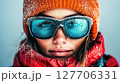 Mountain adventure with a young woman wearing winter gear in snowy conditions, showcasing determination and style while exploring the outdoors 127706331