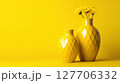Bright yellow vases with flowers create a cheerful atmosphere in a minimalist setting 127706332