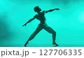 Dynamic dance performance captured under vibrant green lighting showcases athleticism and artistic expression in a modern theatrical setting 127706335