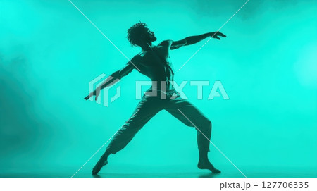 Dynamic dance performance captured under vibrant green lighting showcases athleticism and artistic expression in a modern theatrical setting 127706335