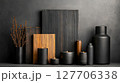 Decorative arrangement of black vases and candles with wooden panels in a minimalist setting 127706338