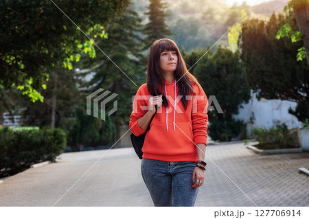 A young pretty caucasian woman with a backpack is going on an adventure. Outdoor 127706914