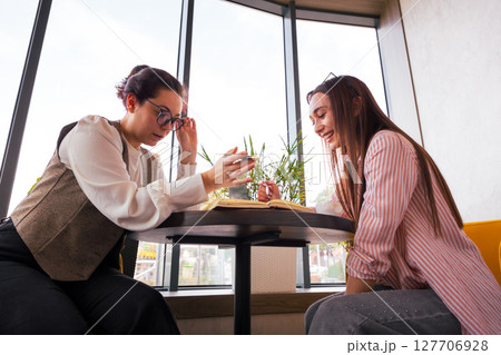 Strategic conversation between two young Caucasian women building brand architecture and planning their digital business direction. Bottom view Strategic conversation between two young Caucasian women building brand architecture and planning their digital business direction. Bottom view 127706928