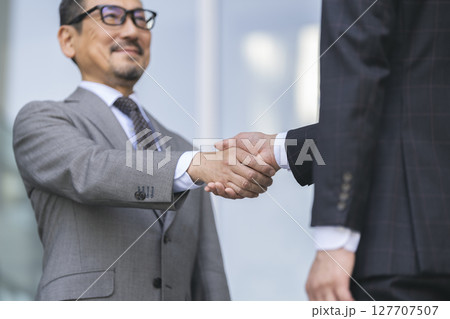 握手をするビジネスマン 127707507