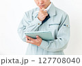 グリーンの作業服を着てバインダーとペンを持つミドル男性ビジネスマン 127708040