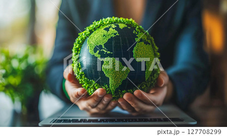 The man's hands hold a model of the Earth covered with green plants, symbolizing ecology and environmental protection. 127708299